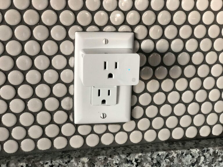 Close-up of a smart plug on a tiled wall showcasing contemporary interior design style.