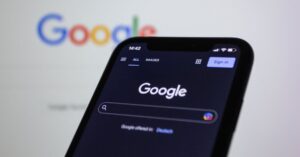 Smartphone mostrando a tela inicial do Google. (Foto: Pexels)