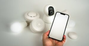 Celular ao lado de uma câmera de segurança. (Foto: Pexels)